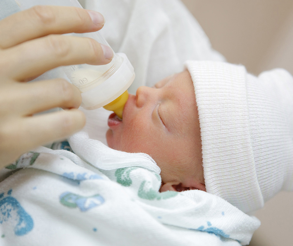 Newborn baby being bottle fed