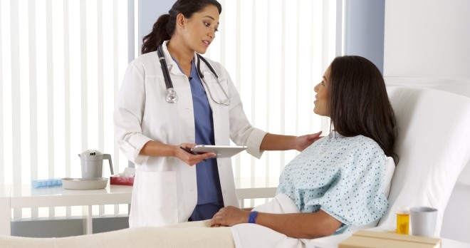 Doctor talking to woman patient in a hospital bed