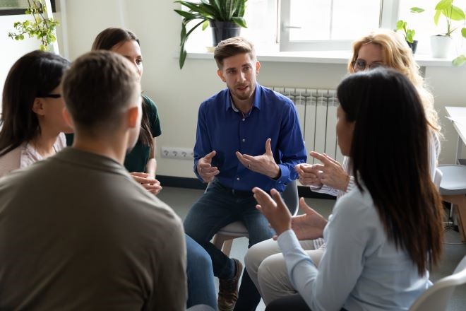 Diverse group of people sitting in a circle talking