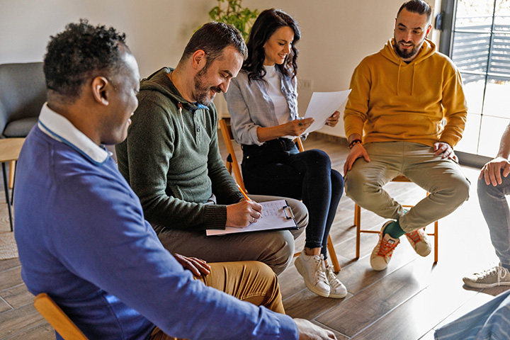 A group of people are sitting in a circle and engaging in a lively discussion