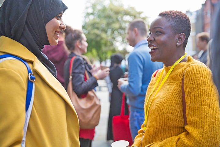 Two people are speaking enthusiastically to each other