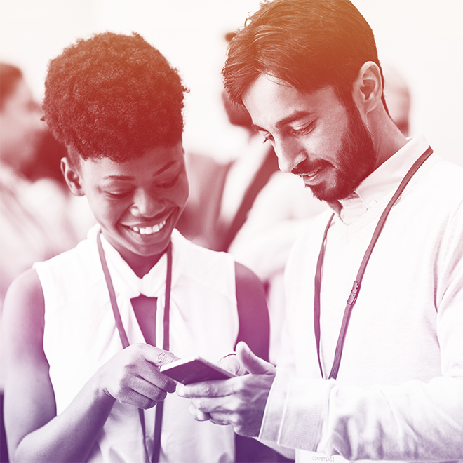 Man and woman smiling and viewing a mobile device