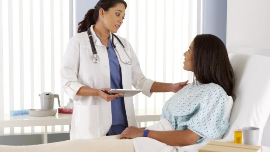 Doctor talking to woman patient in a hospital bed