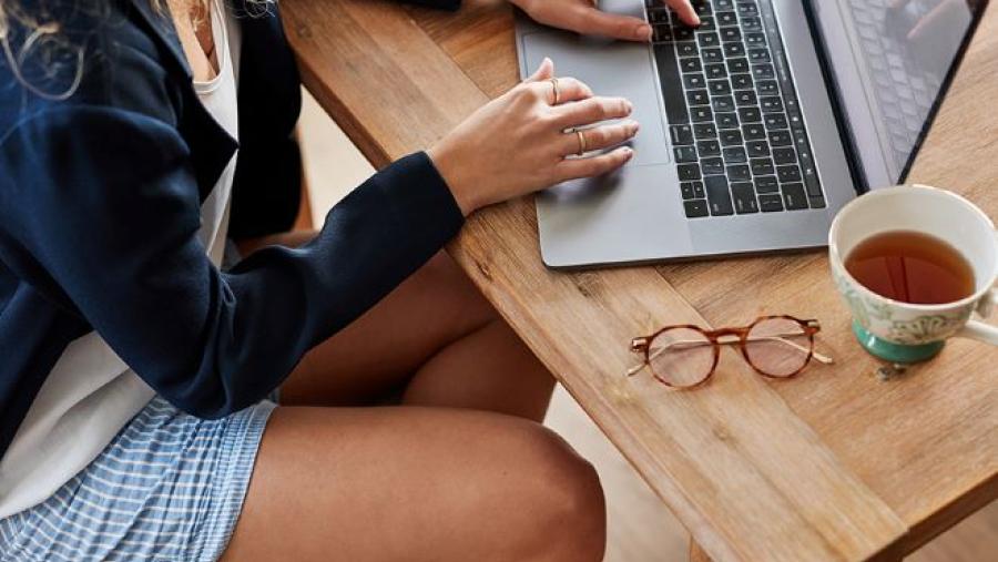 woman sitting at a table working on a laptop computer