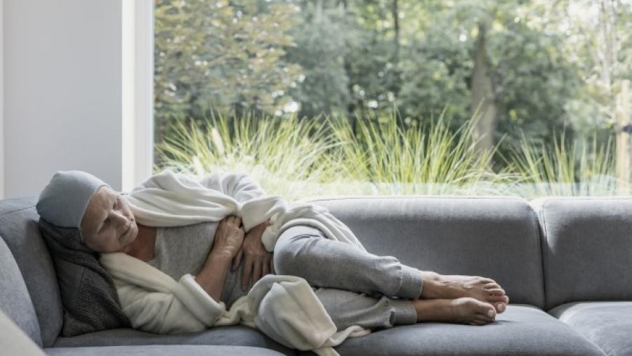 women experiencing chronic pain laying on couch