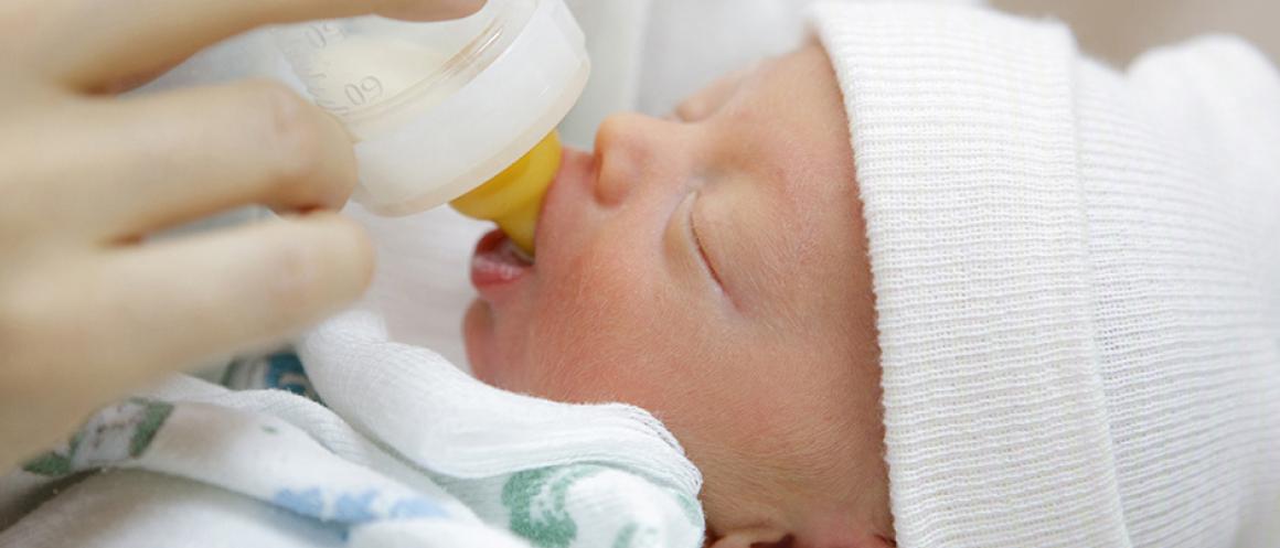 Newborn baby being bottle fed