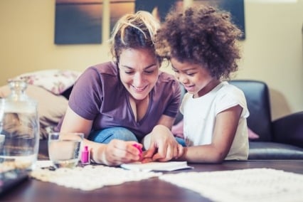 A mother paints her daughter's nails