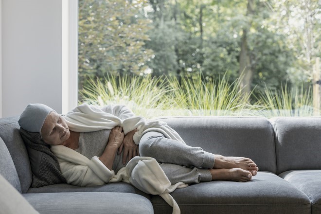 women experiencing chronic pain laying on couch